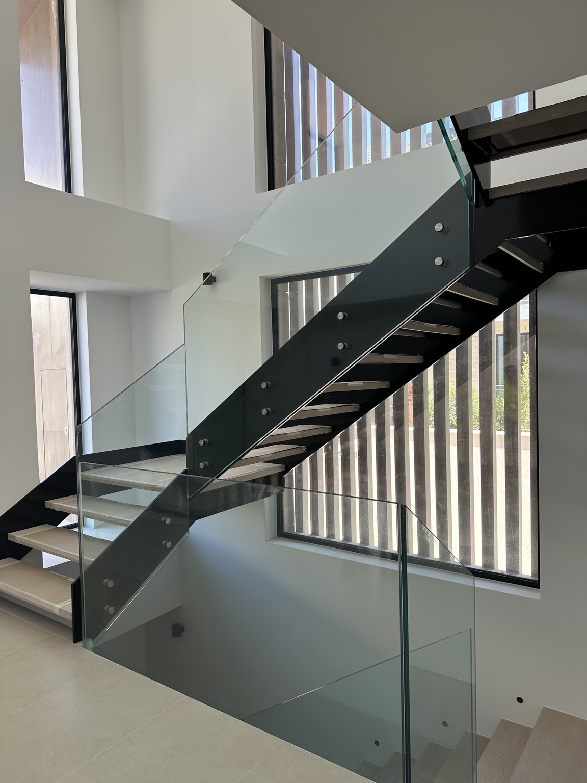 Estrutura metálica da escada pintada de preto, com degraus protegidos durante a obra